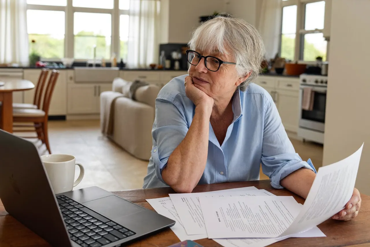 Homeowner reviewing a written glazing quote at a kitchen table
